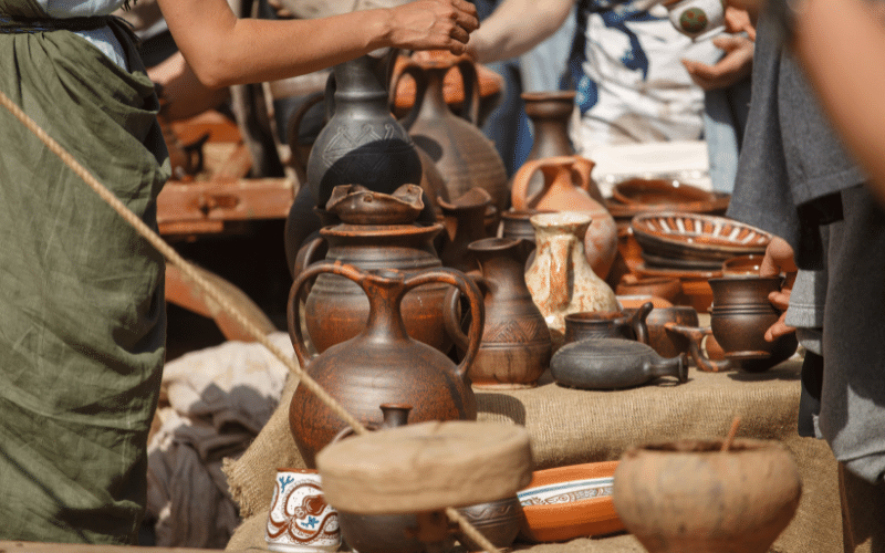 Handmade terracotta pots, jugs and bowls laid out on a market stall