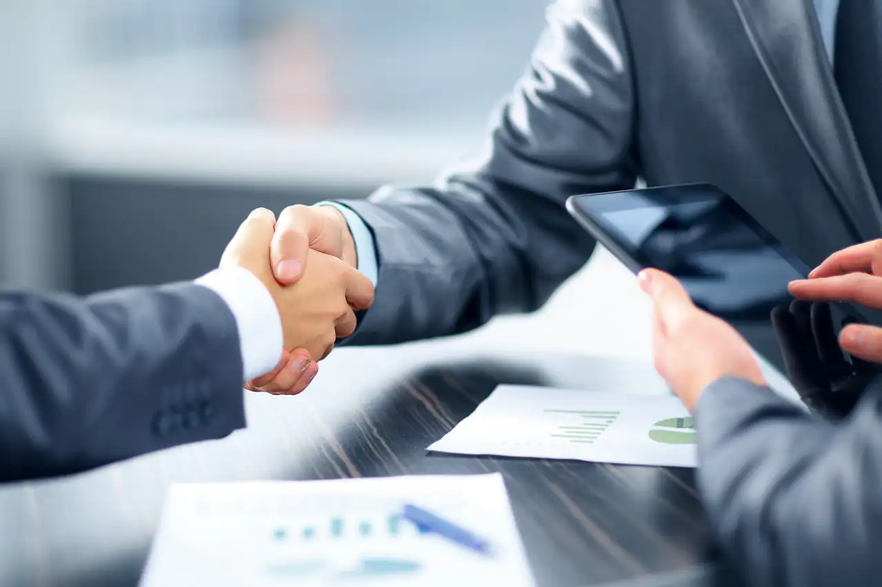 A handshake across a meeting table