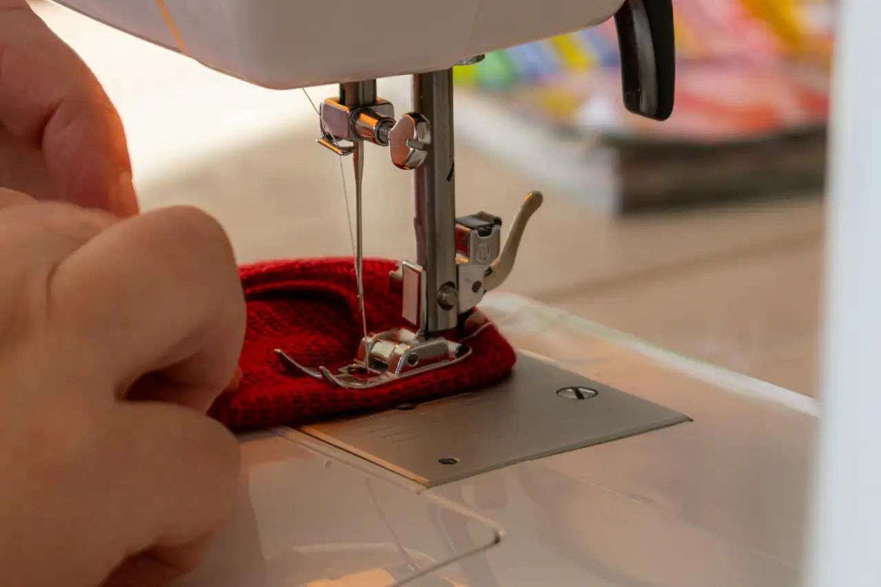 A machinist guiding fabric under the needle