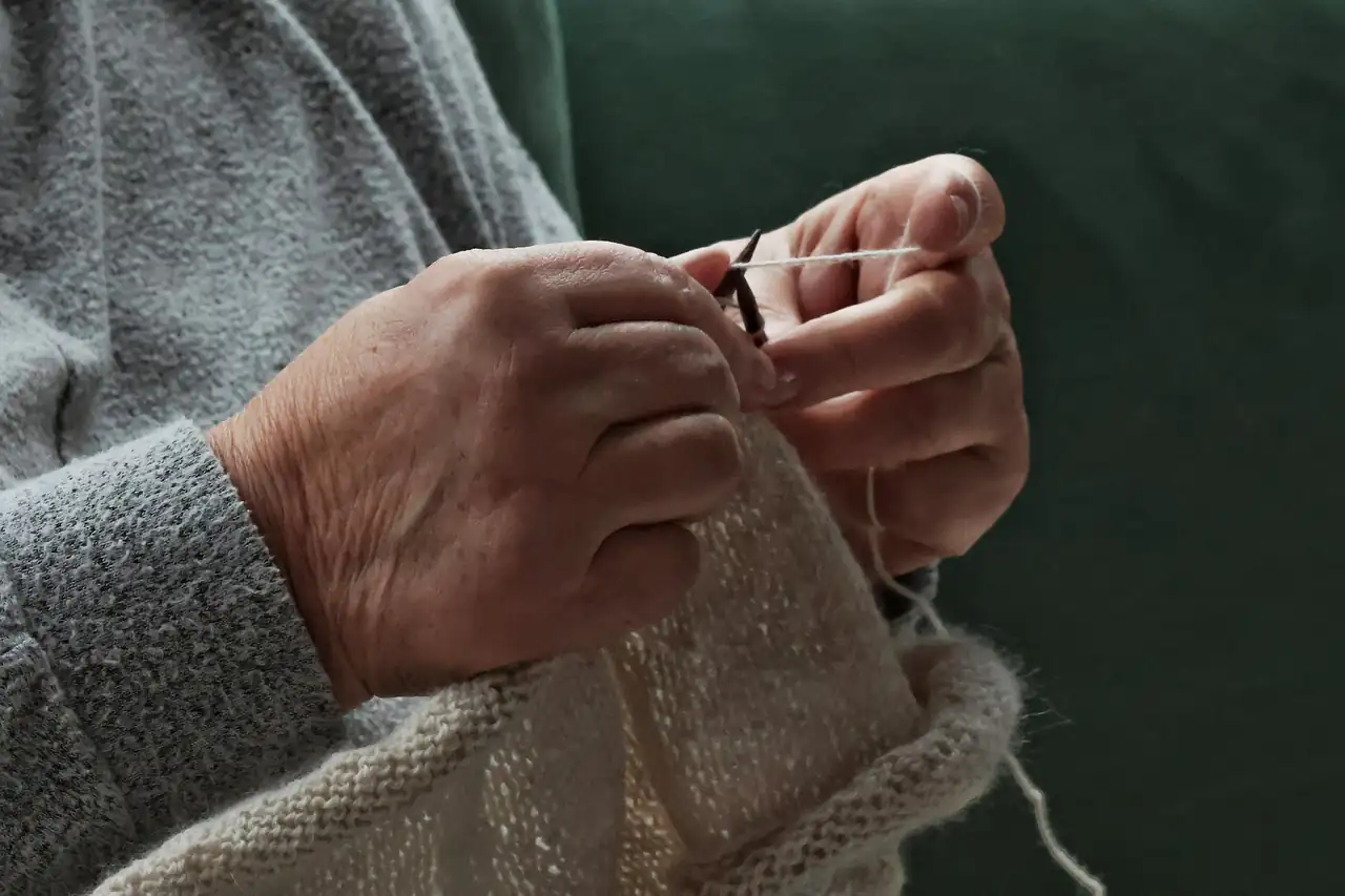 Hands checking the stitching on a garment