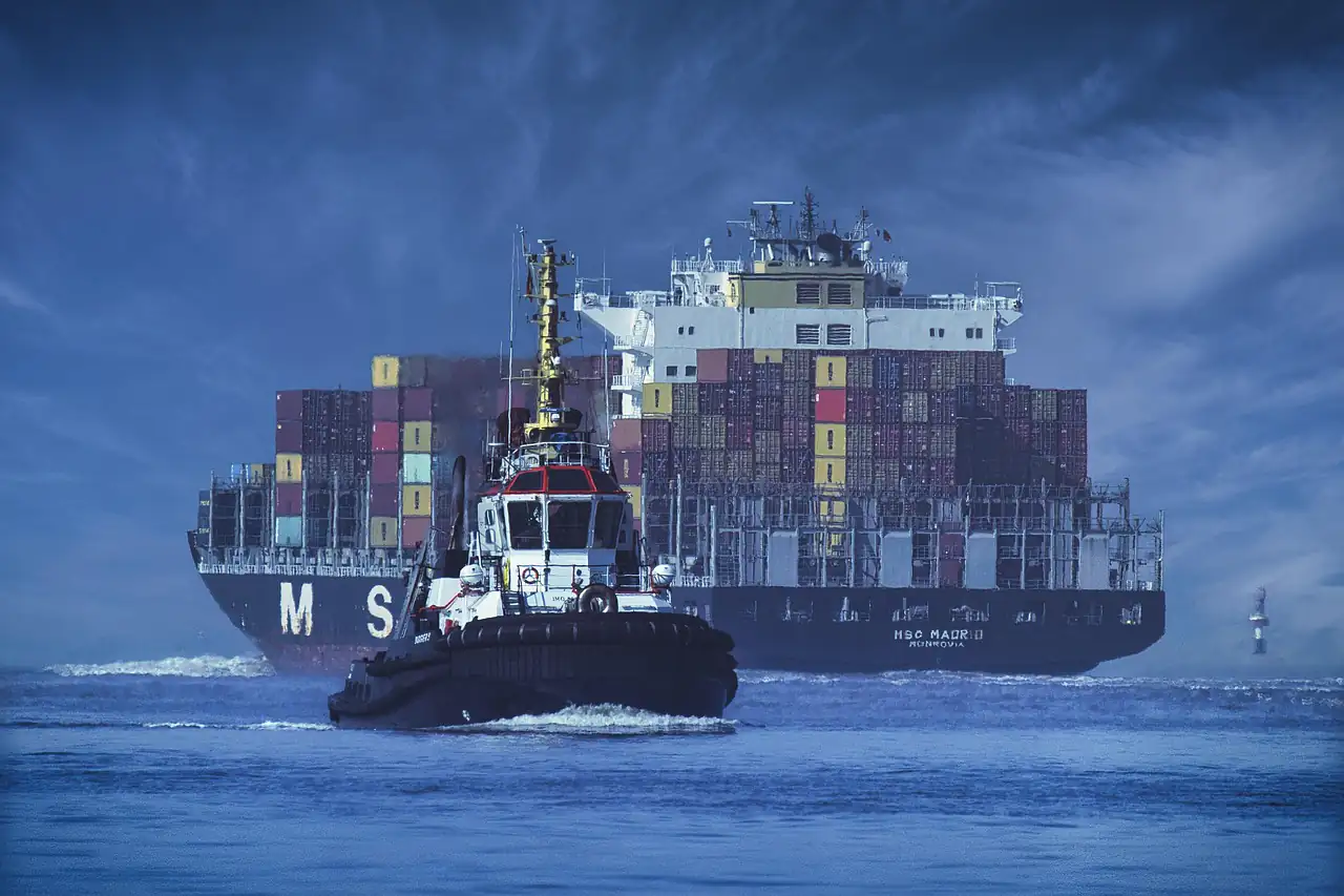 A container ship with a tug alongside