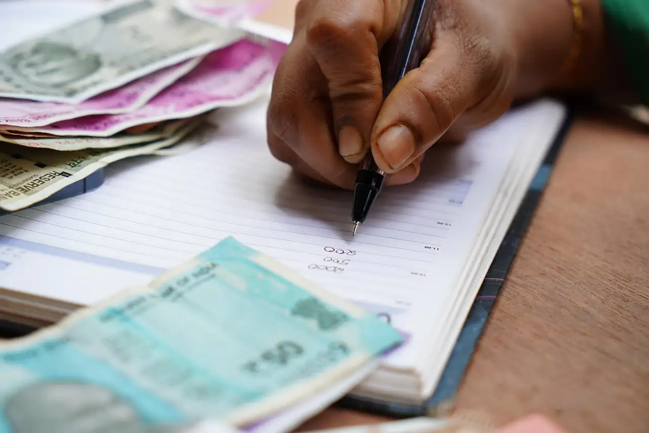 Filling in a bank slip with rupee notes