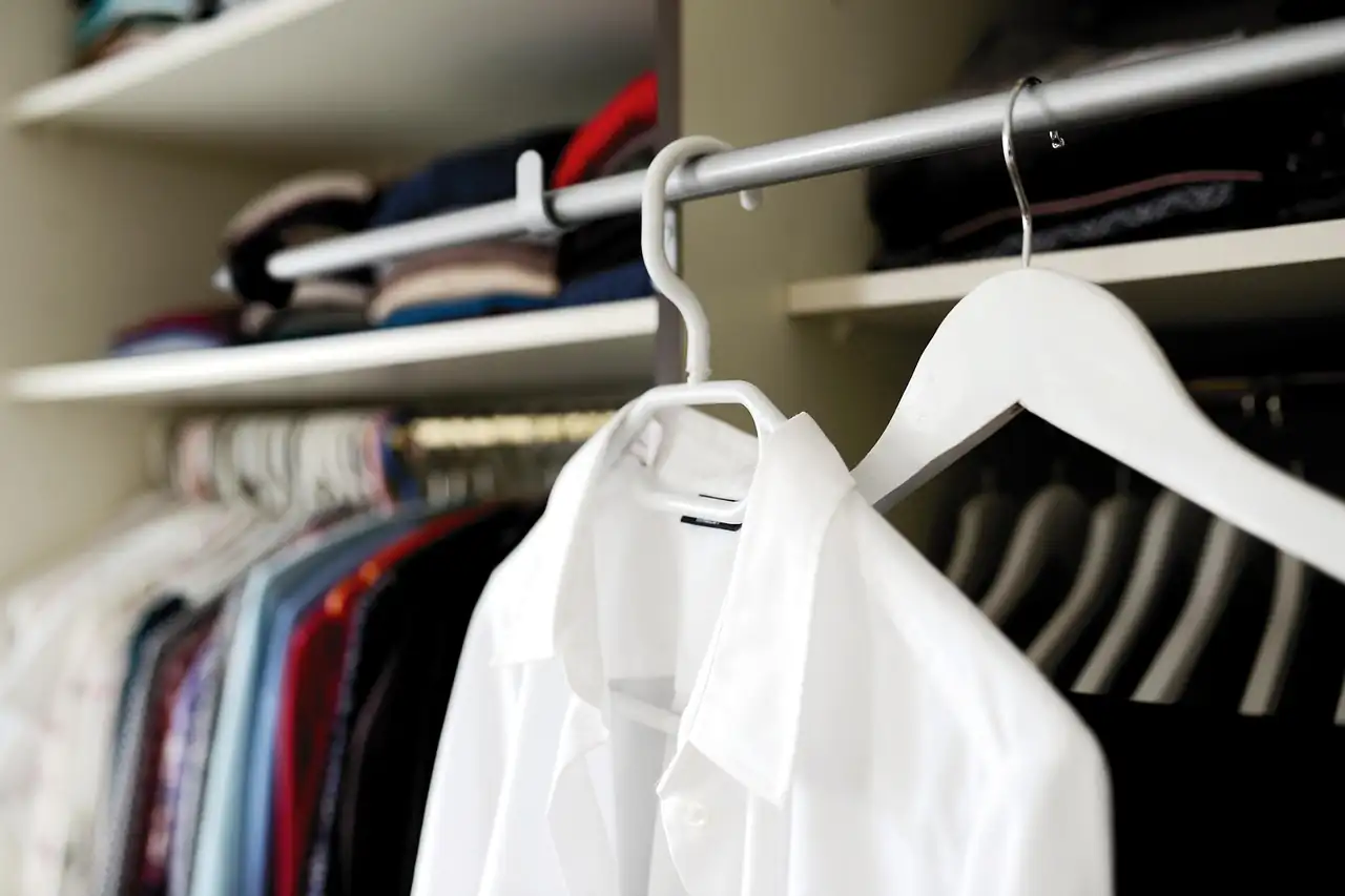 A white shirt on a hanger in a wardrobe