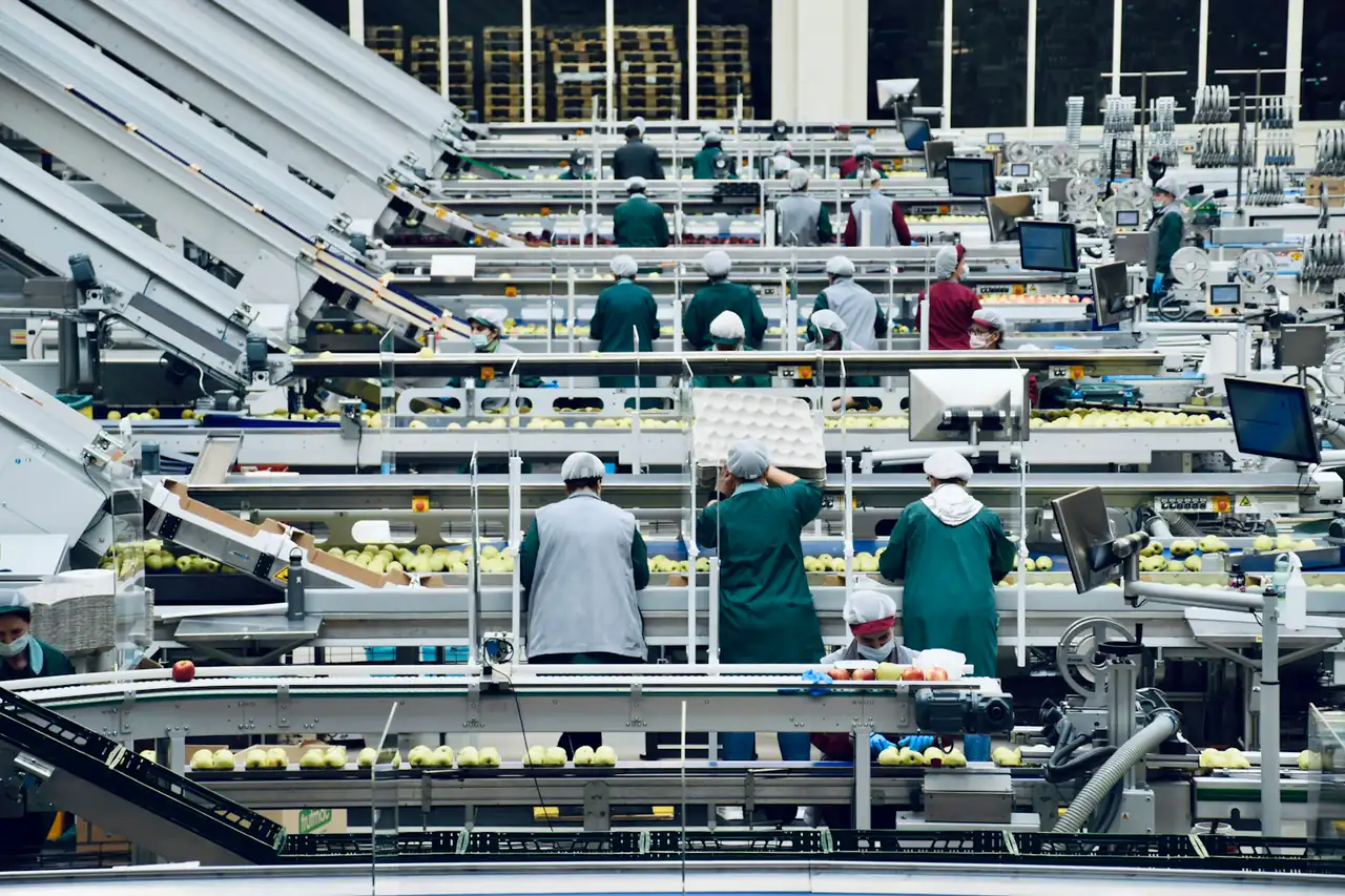 Workers along an electronics assembly line in a factory