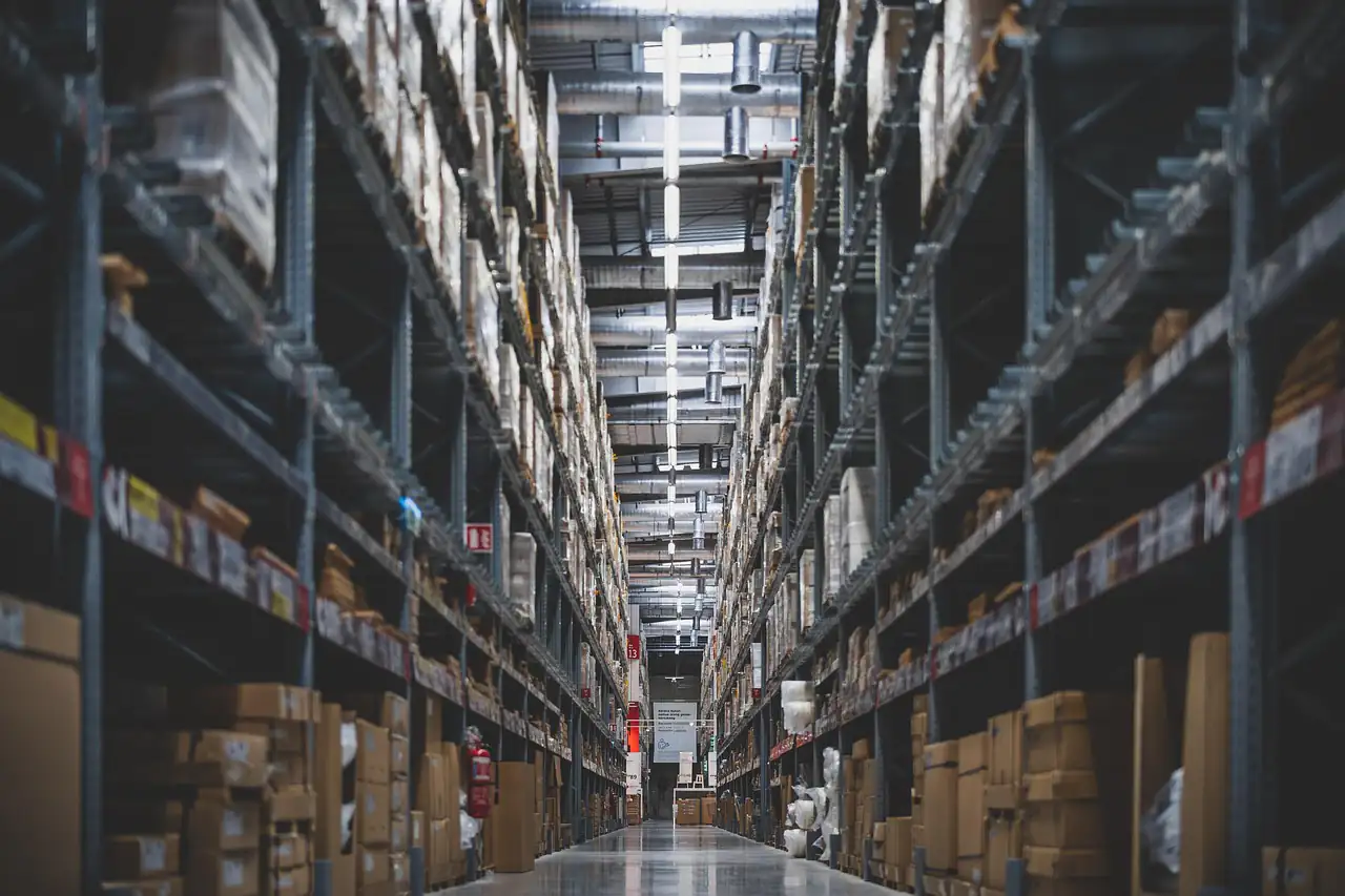 Tall racks of boxed goods along a warehouse aisle