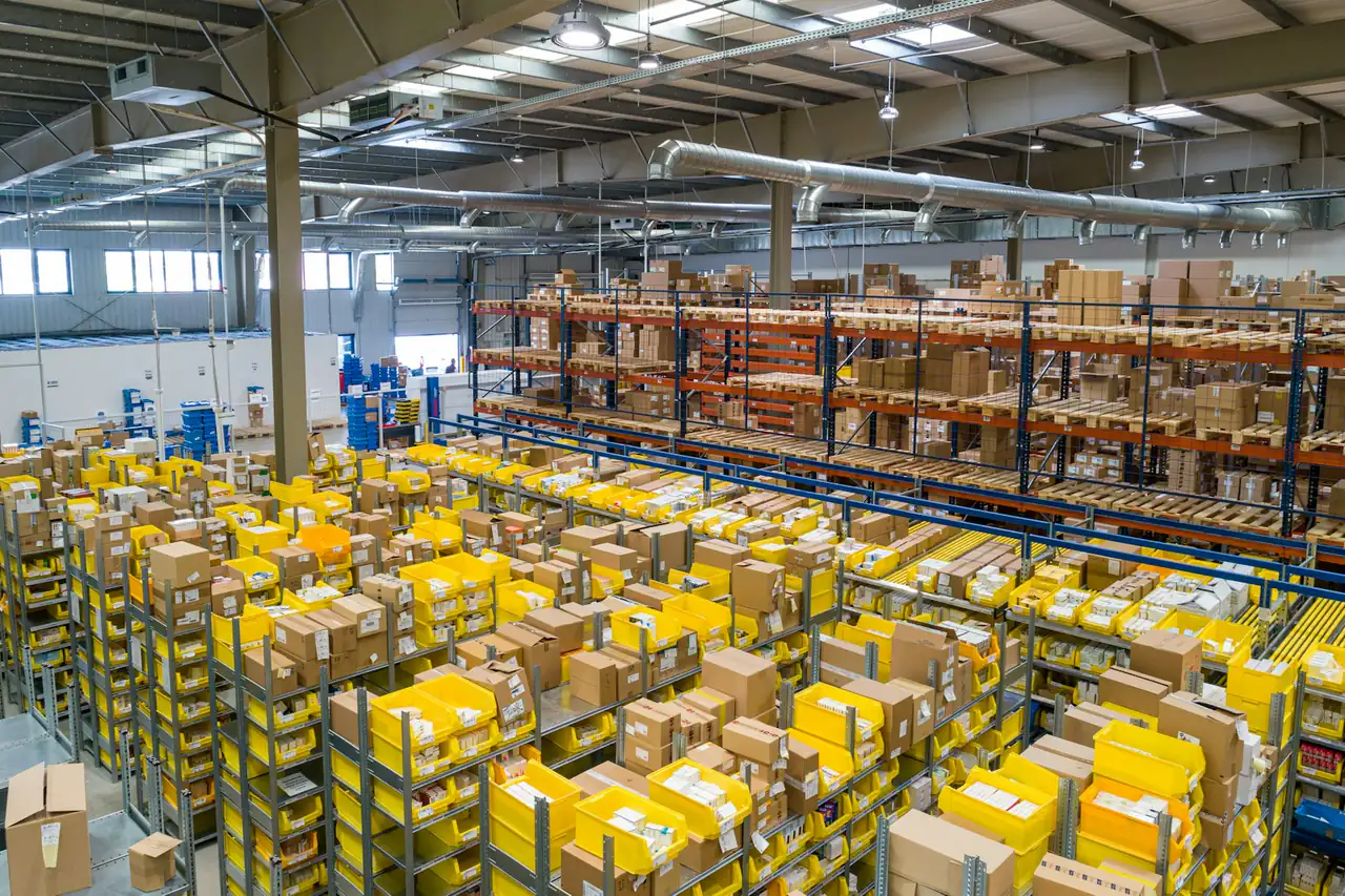 Cartons stacked on high shelving in a large warehouse