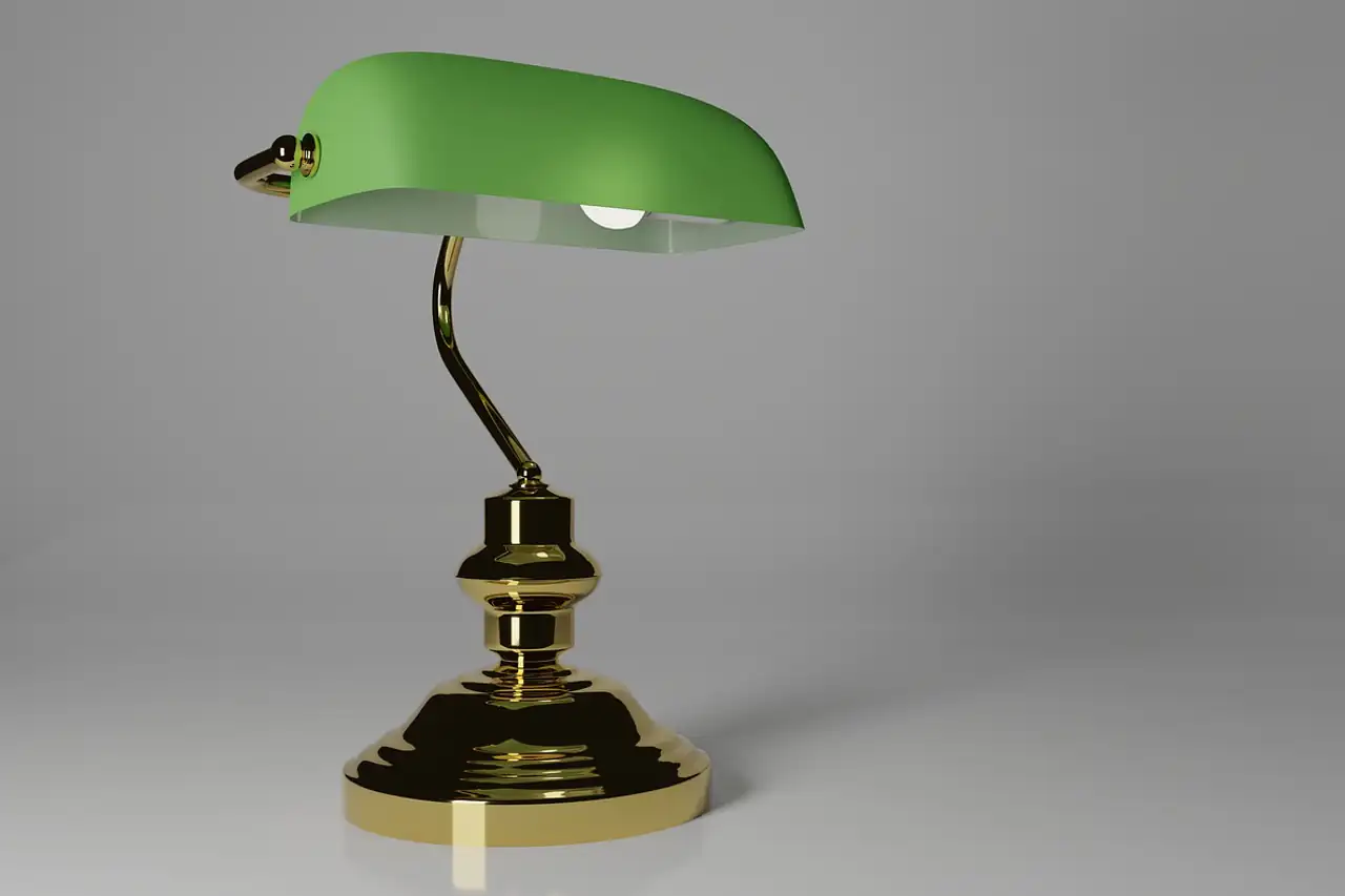 A brass desk lamp with a green glass shade