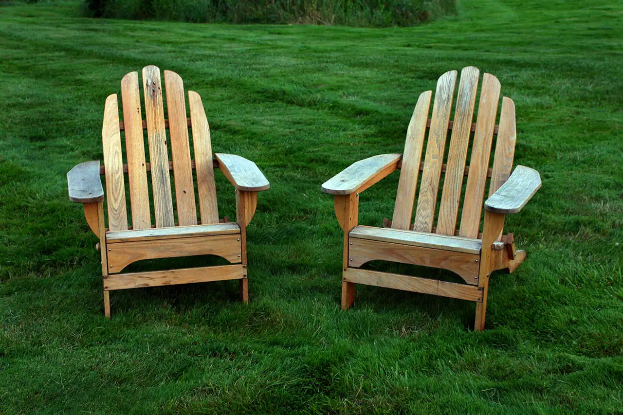 Two wooden garden chairs on a lawn