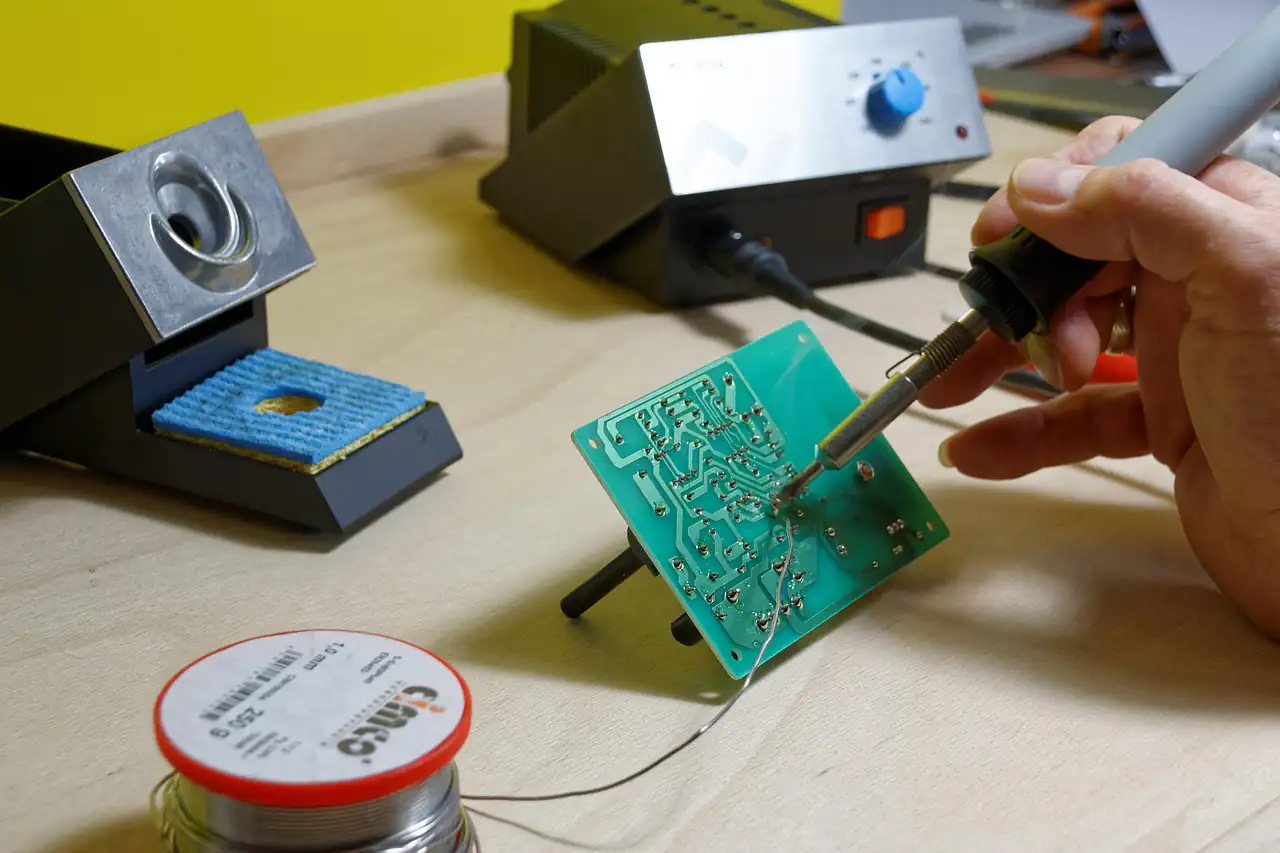 A hand soldering components onto a circuit board
