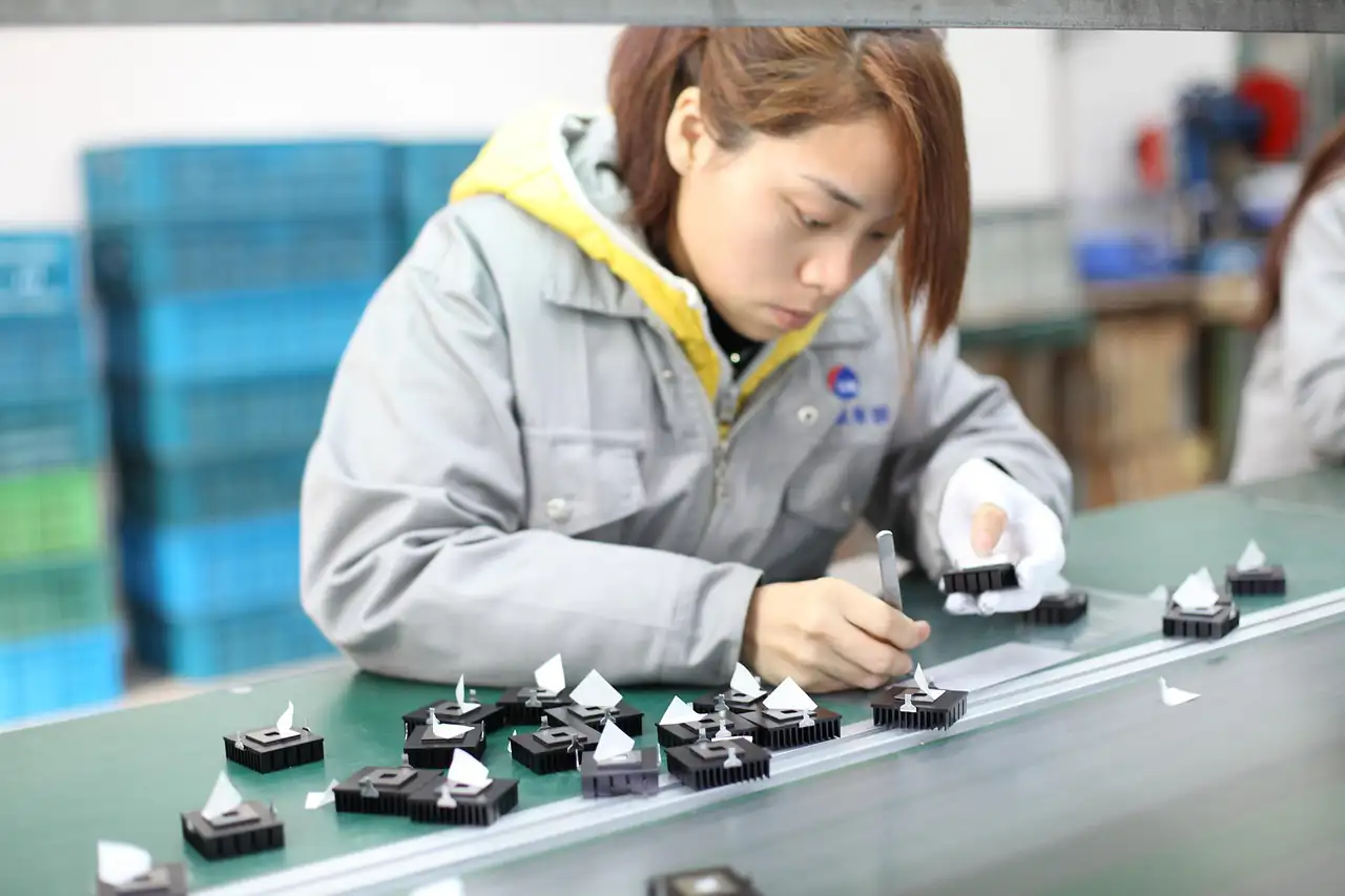A worker assembling small electronic parts on a production line