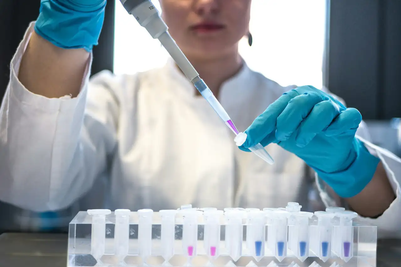 A technician pipetting samples in a lab