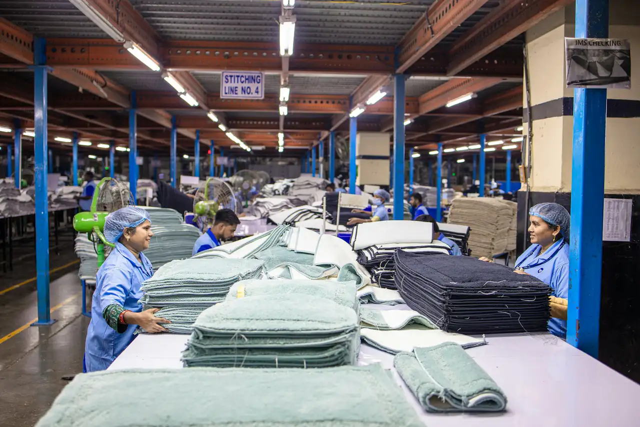 Workers at long tables in a textile factory