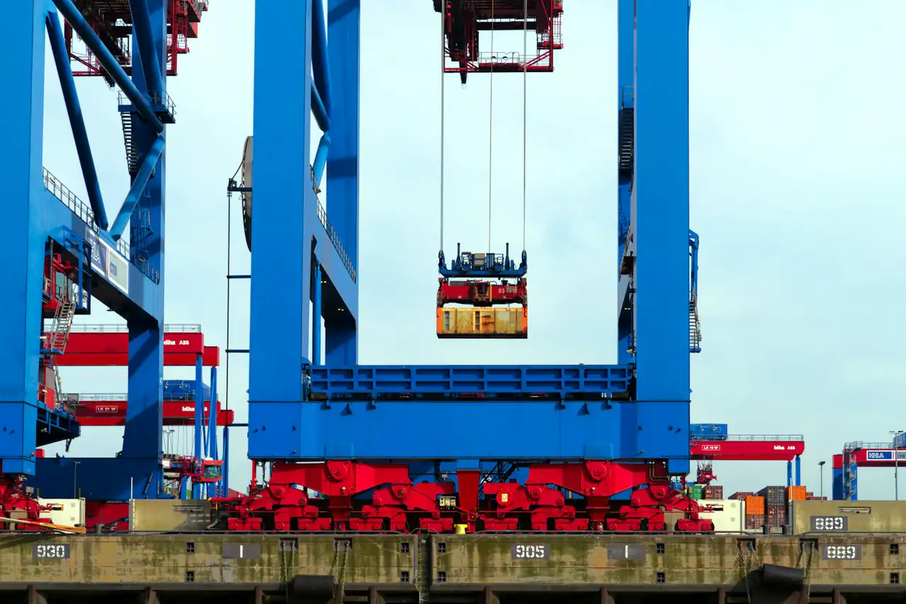 A container lifted by a gantry crane between its legs