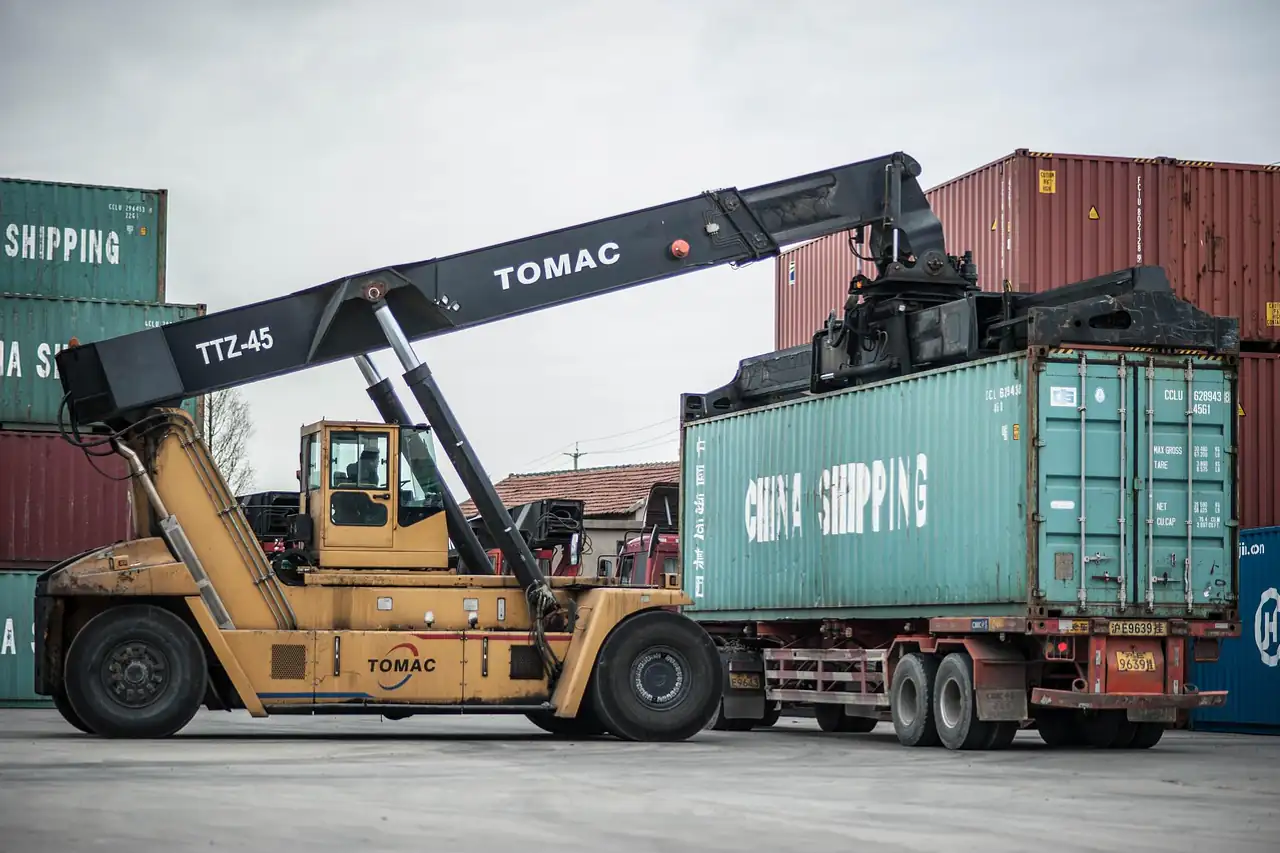A reach stacker lifting a container off a truck