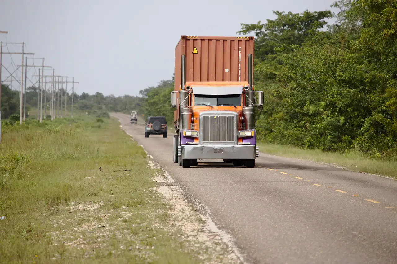 A truck hauling a container along a highway