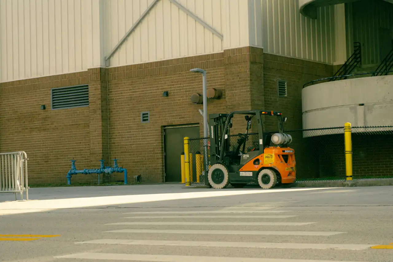 A forklift working outside the loading doors of a warehouse