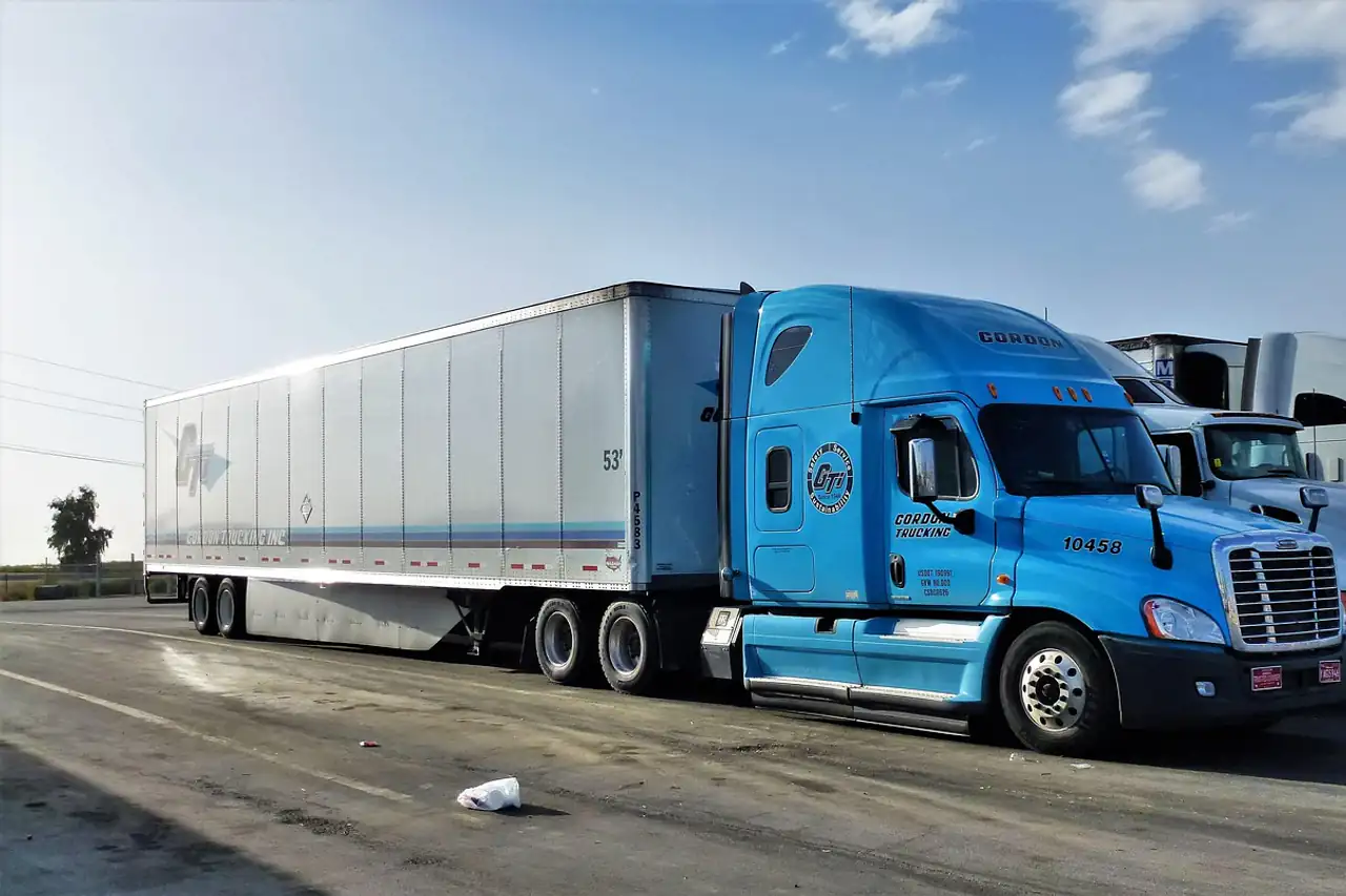 A truck and trailer parked at a distribution yard