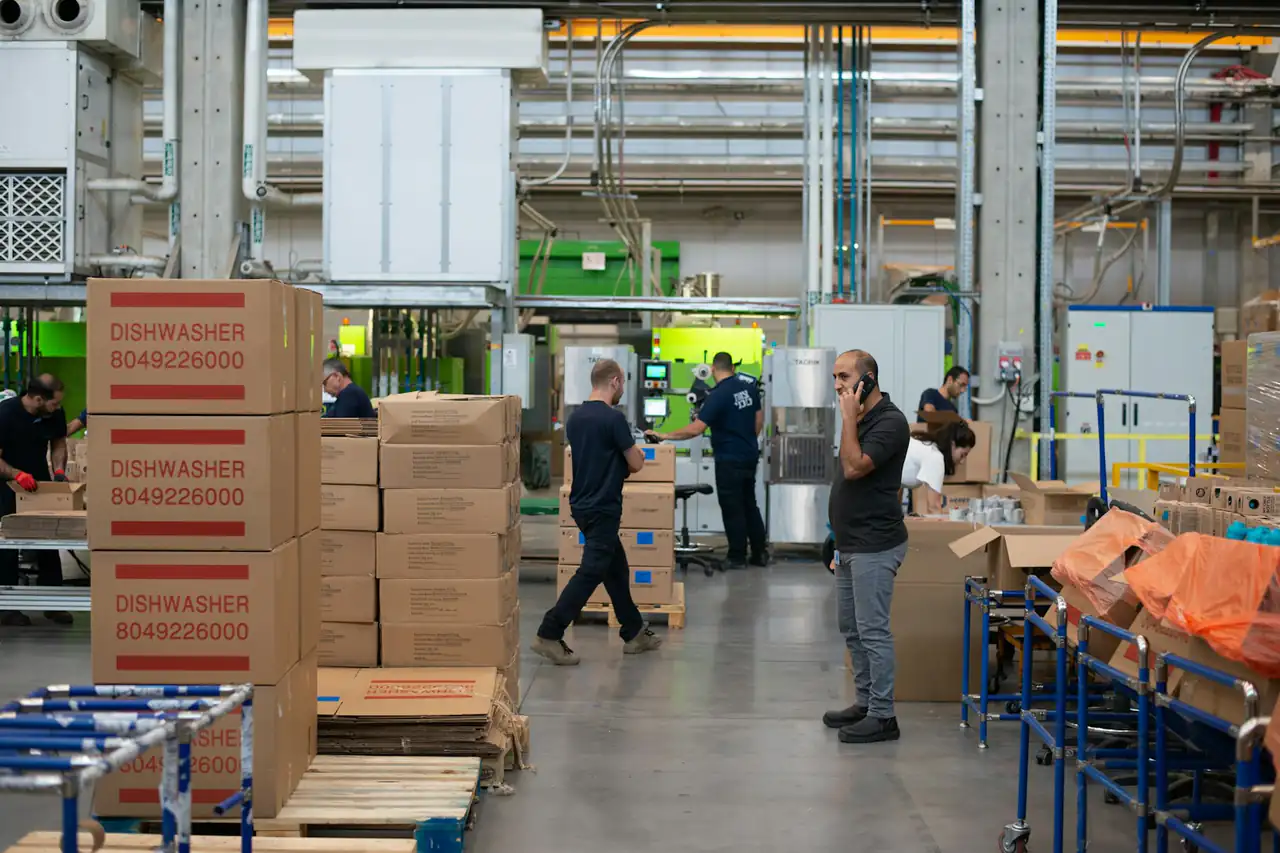 Workers moving boxes between shelves in a warehouse