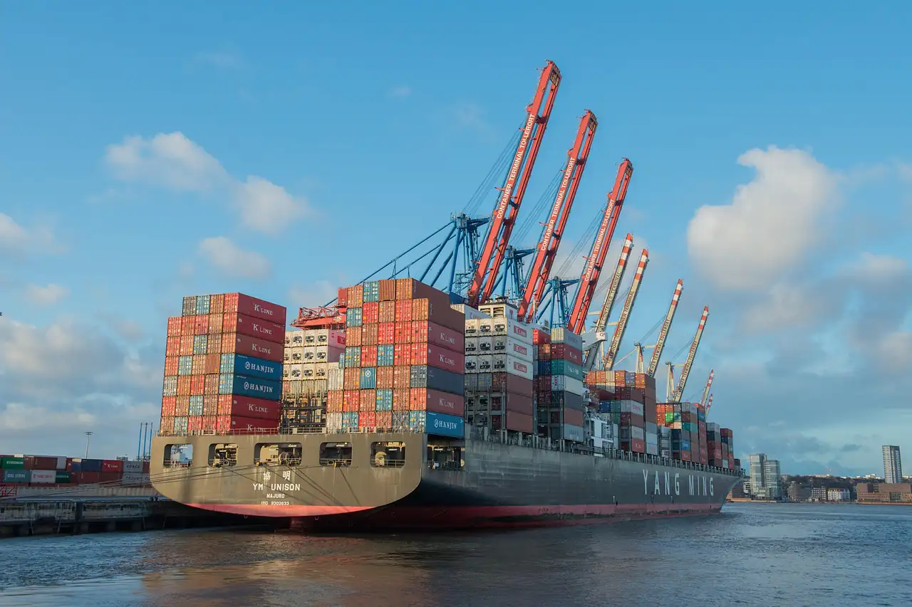 A container ship moored under gantry cranes at a quay