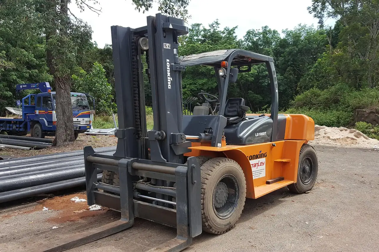 A forklift truck parked on a gravel yard