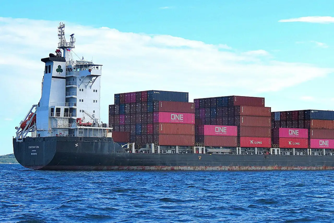A container ship stacked with boxes on a calm sea