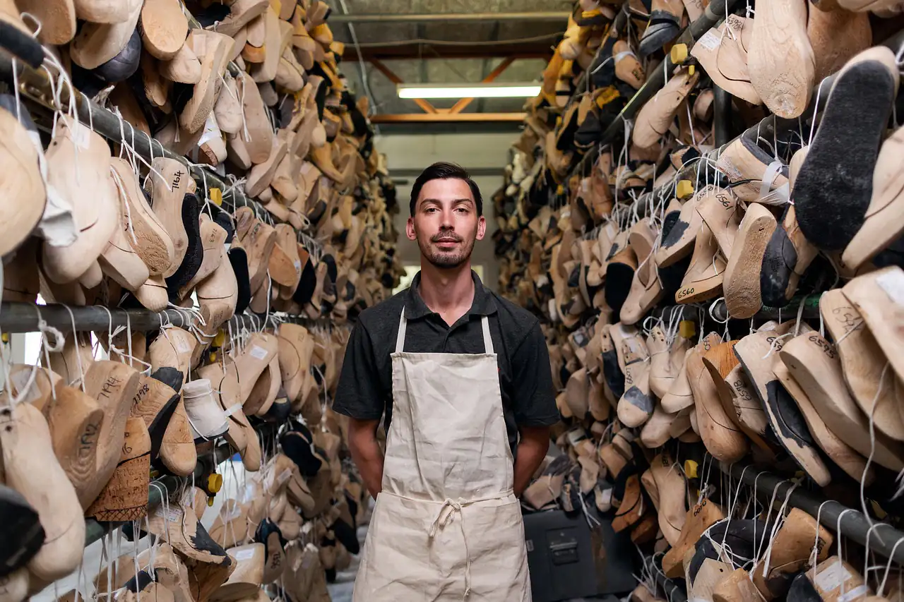 A shoemaker among racks of shoe lasts