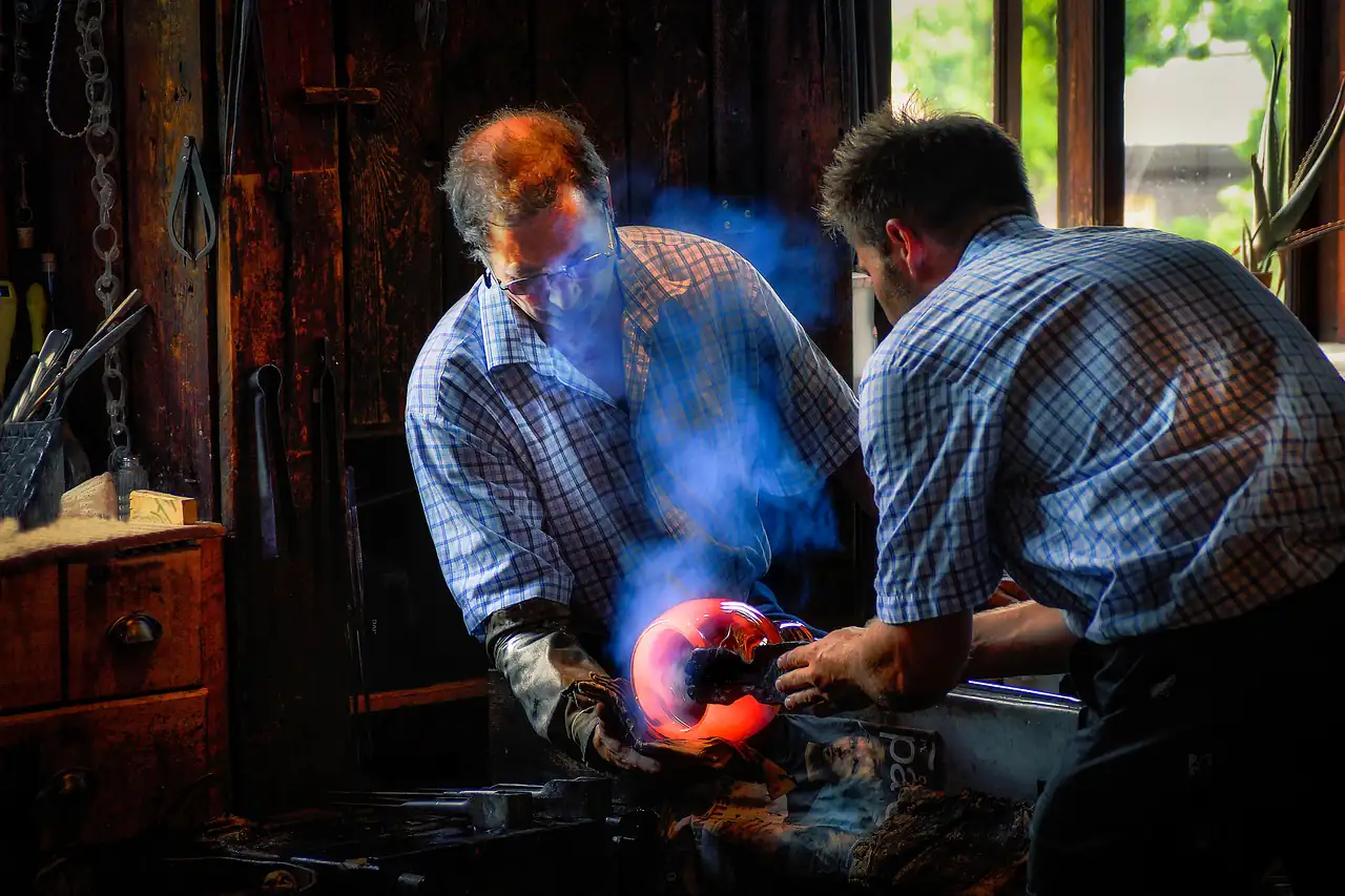 Glassworkers shaping molten glass