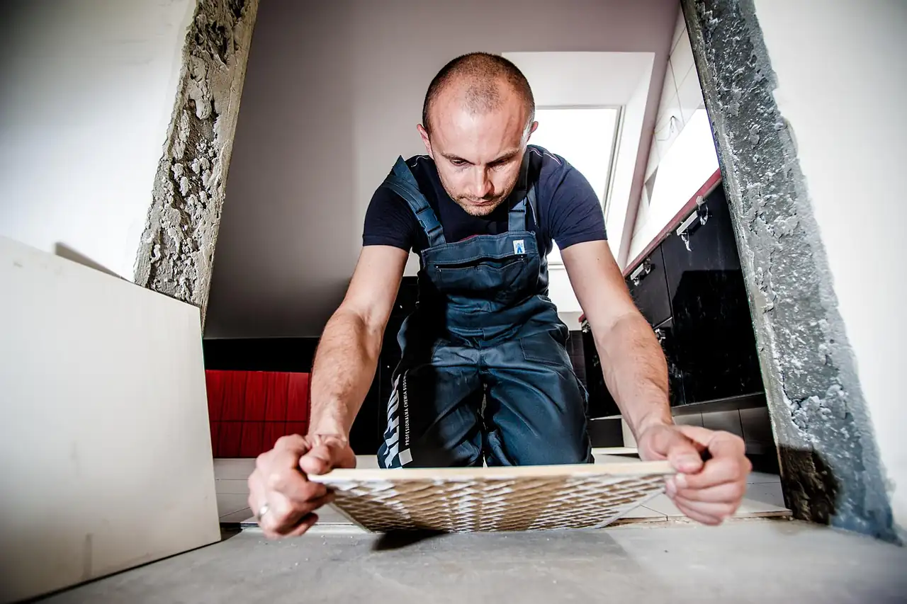 A tiler fitting a ceramic floor tile