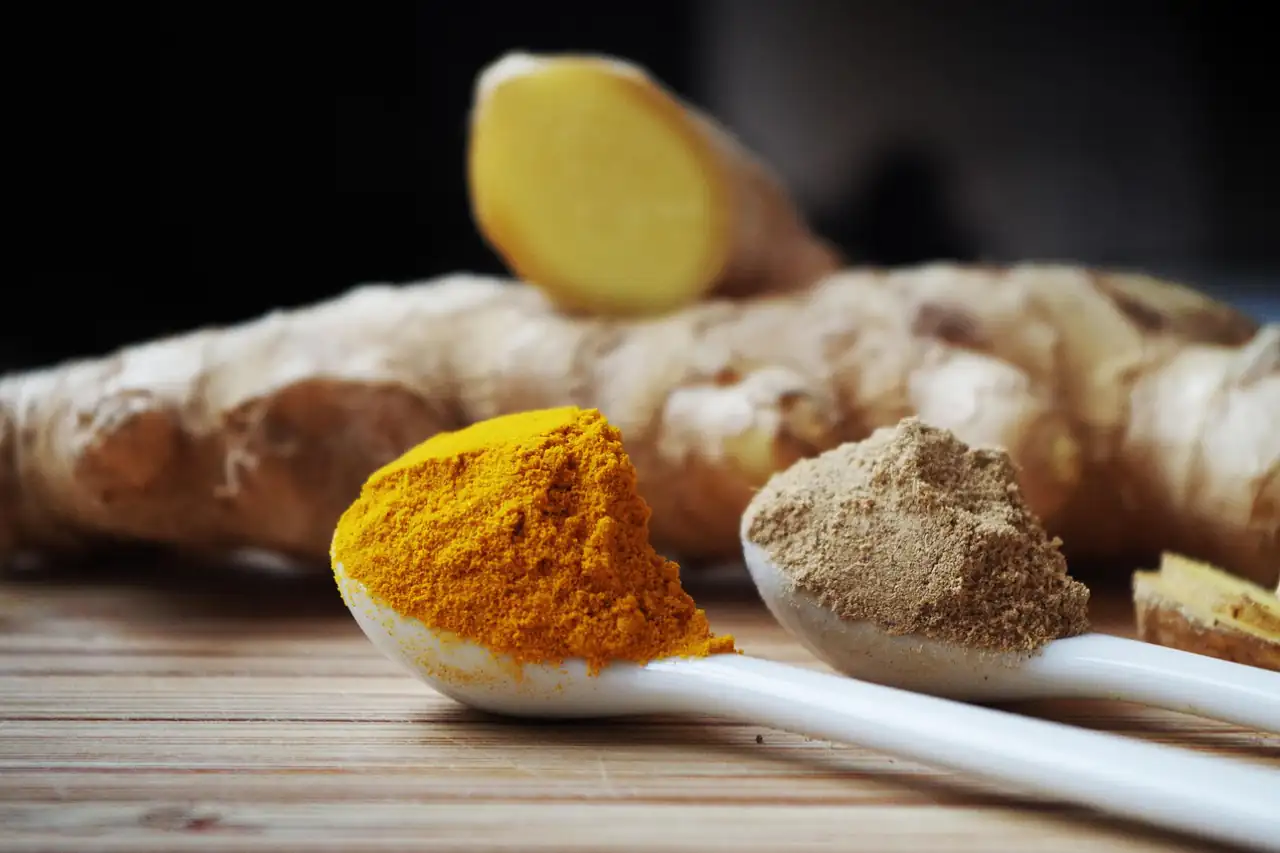 Ground roots and spice powders on a wooden spoon