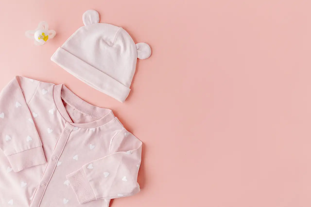 A baby's cotton top and hat laid flat