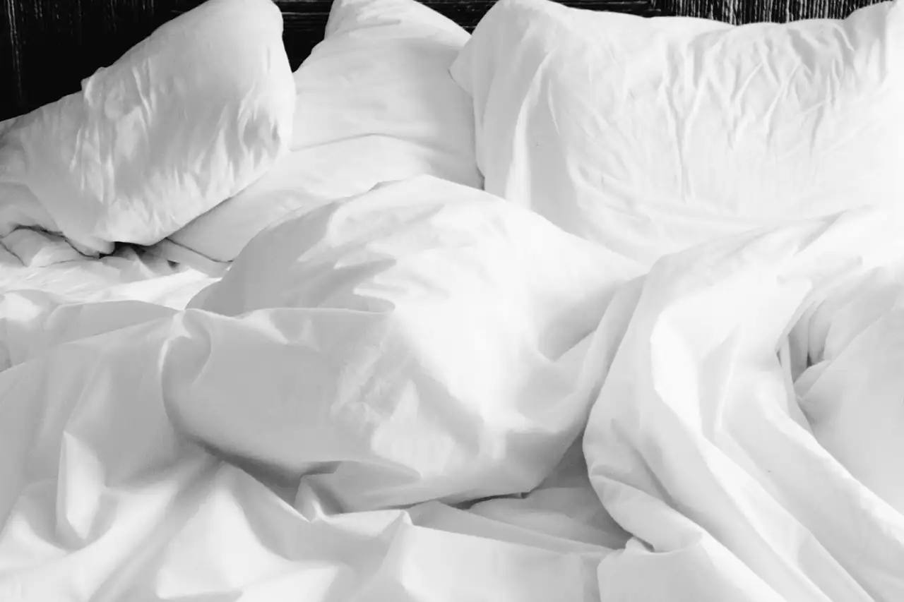 Crumpled white cotton bed sheets