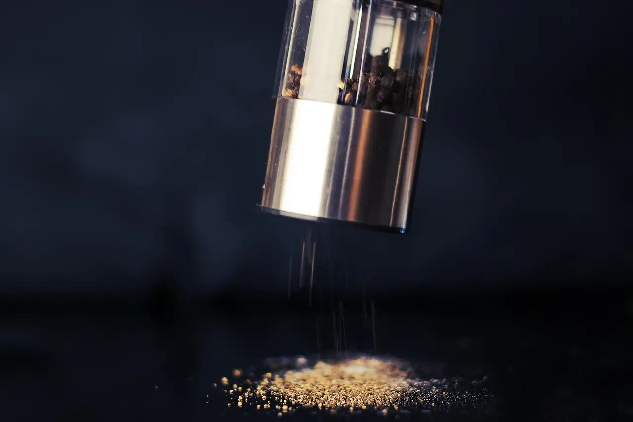 A pepper mill grinding black pepper
