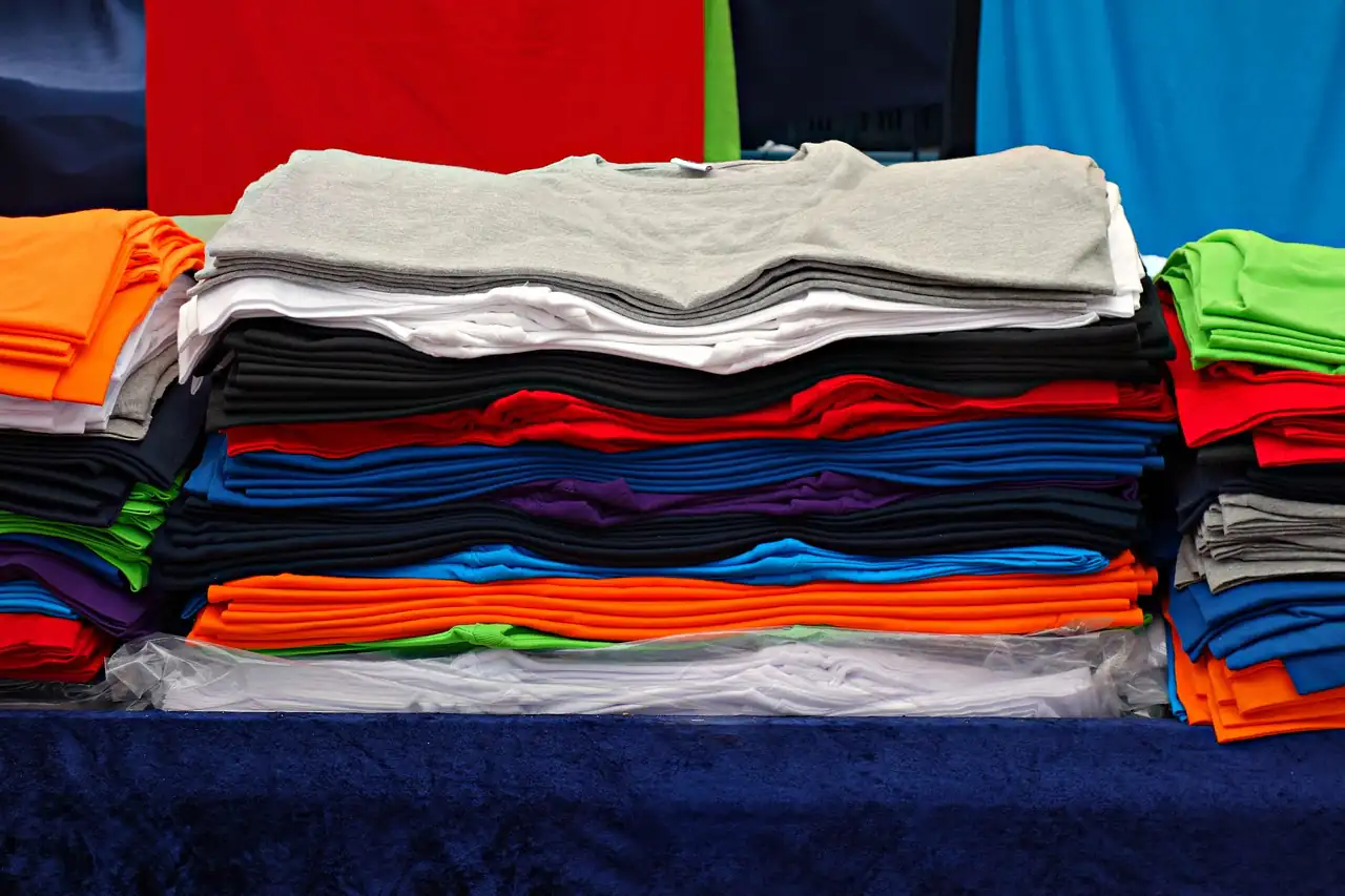 Piles of folded T-shirts in many colours