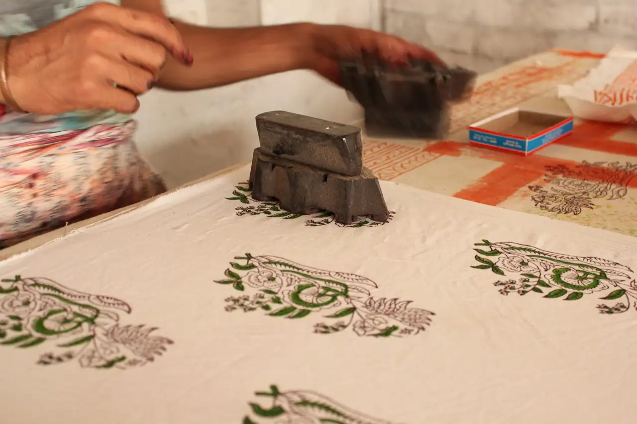 A carved block being printed onto cloth