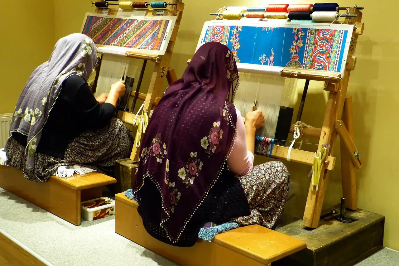 Weavers at upright carpet looms