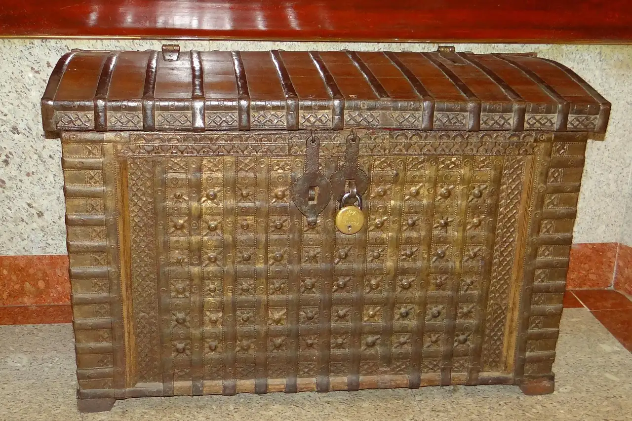 A carved wooden chest with metal fittings