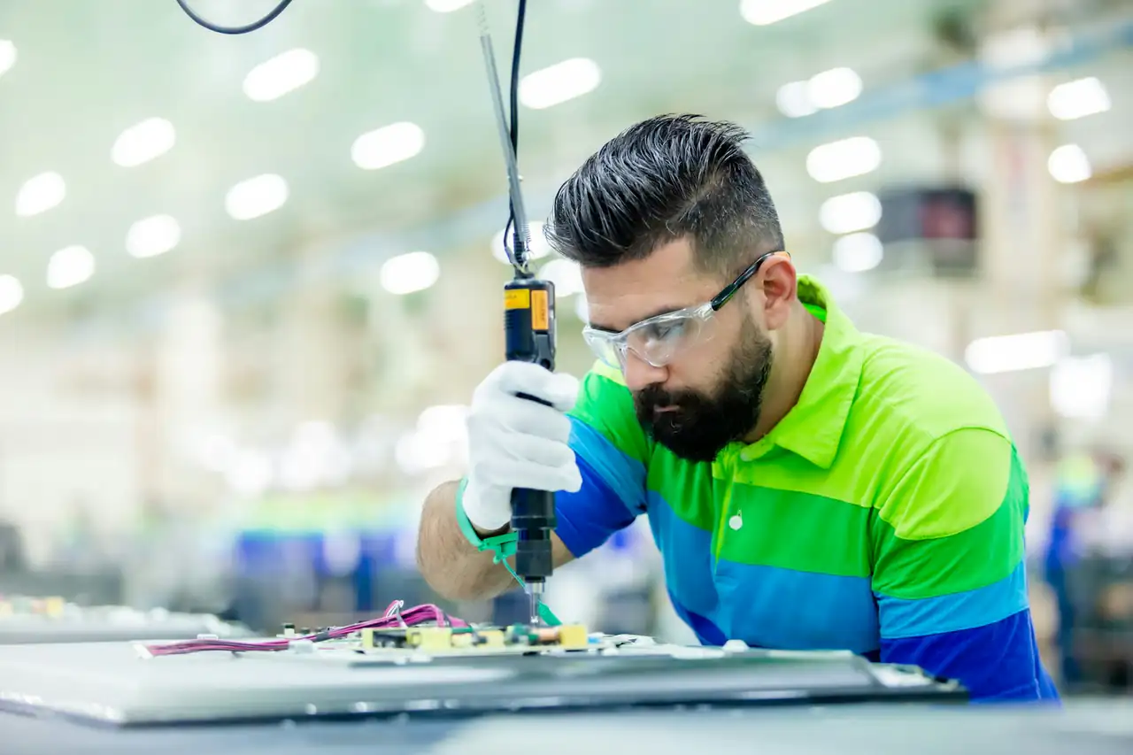 A technician assembling electronics on a production line