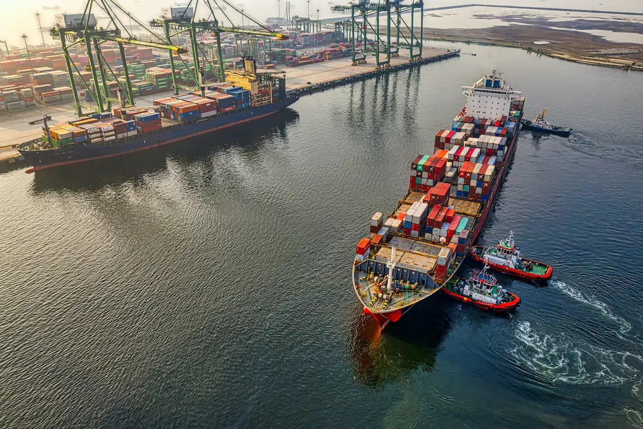 A container ship leaving port, seen from above