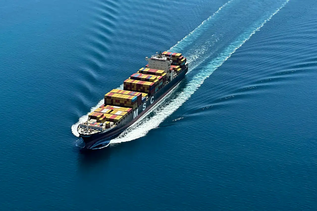 A loaded container ship at sea, seen from above