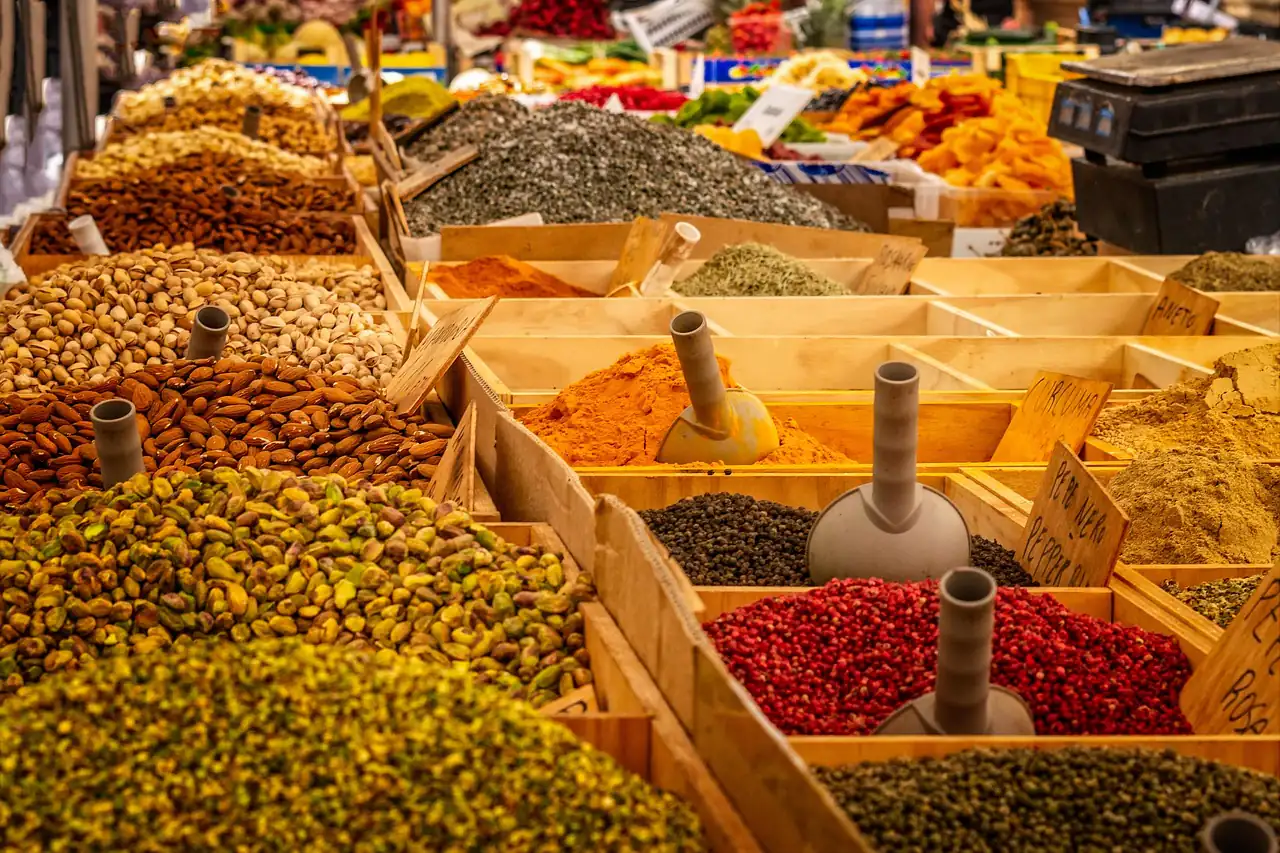 Grains and spices displayed in trays at a market stall