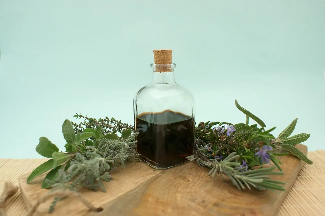 A small bottle of oil among fresh herbs