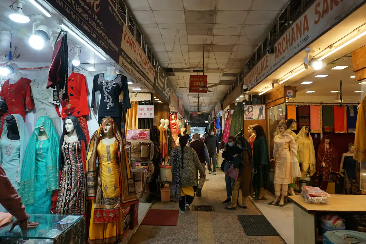 A covered market arcade lined with clothing and textile shops