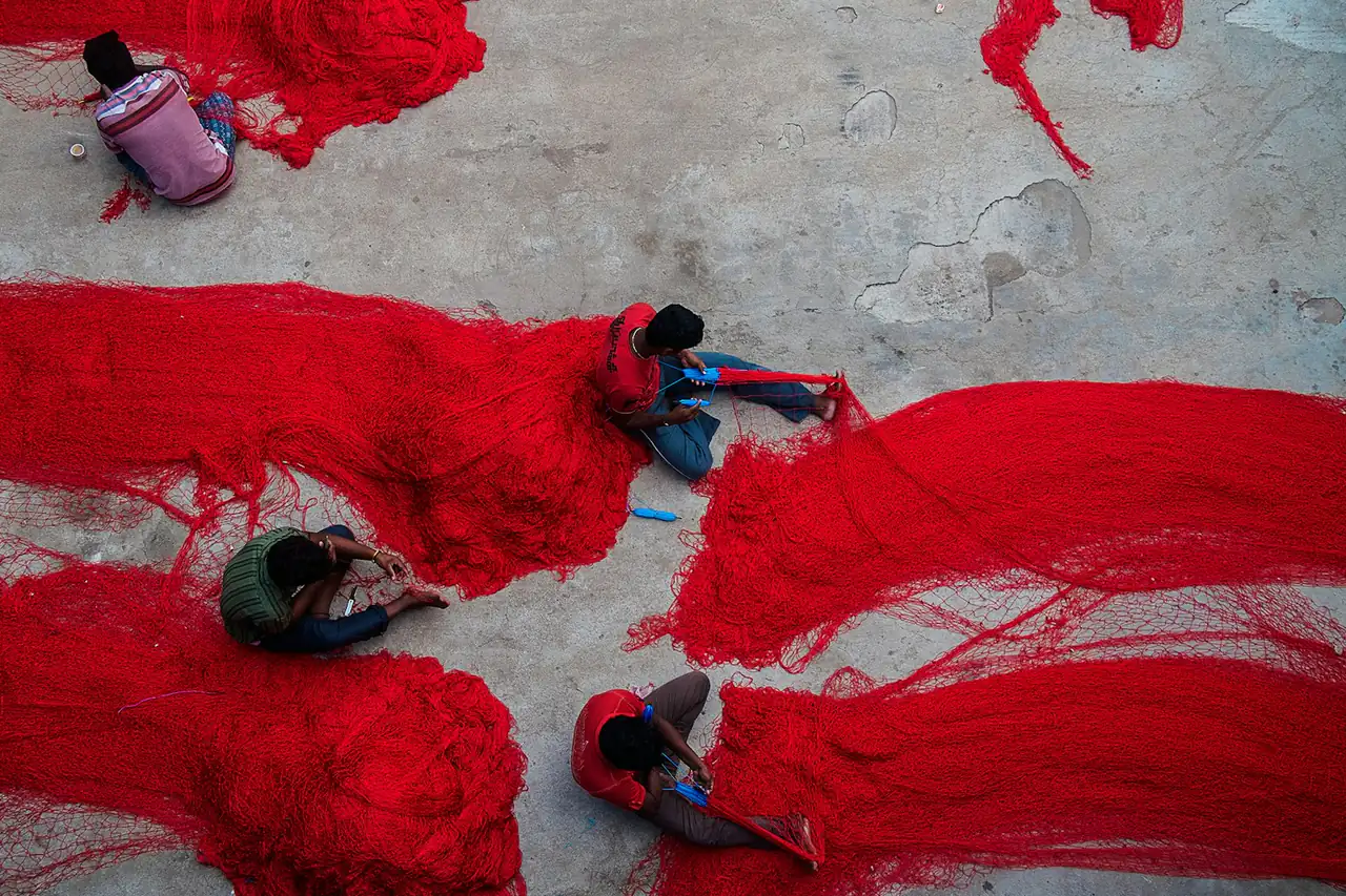 Freshly dyed red yarn laid out to dry on the ground
