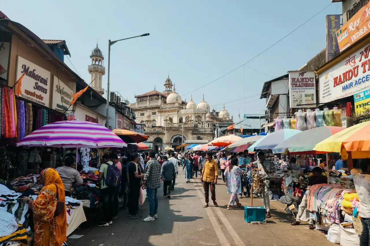 Shoppers and stalls along a busy market street