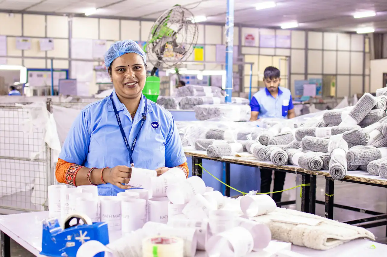 A worker at a packing table in a factory