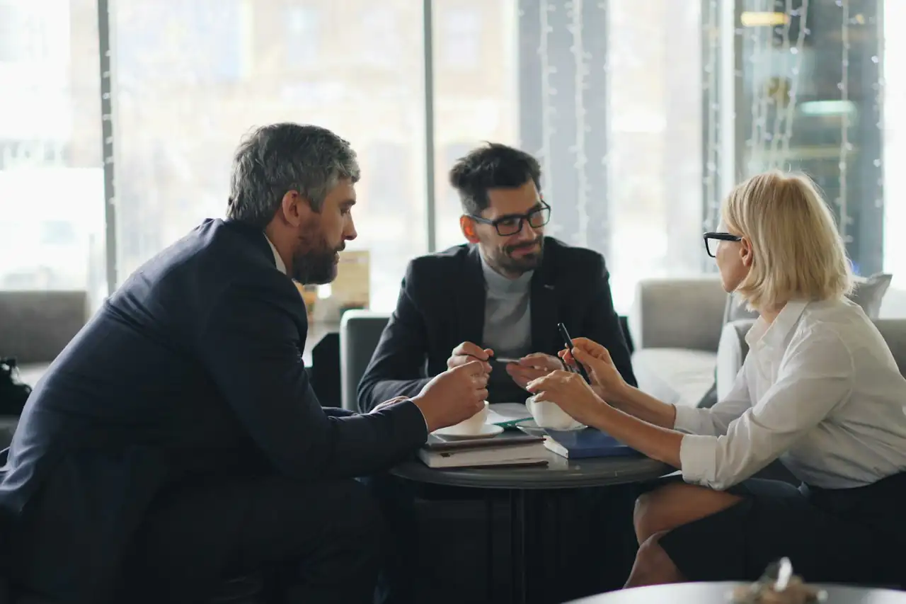 Three people talking business over coffee