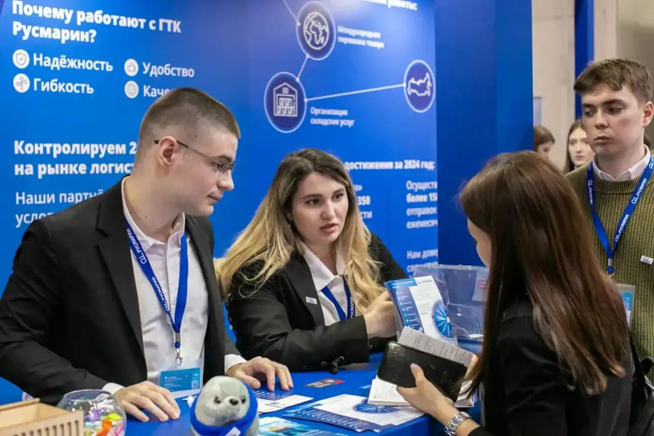 Exhibitors talking to visitors at a trade fair stand
