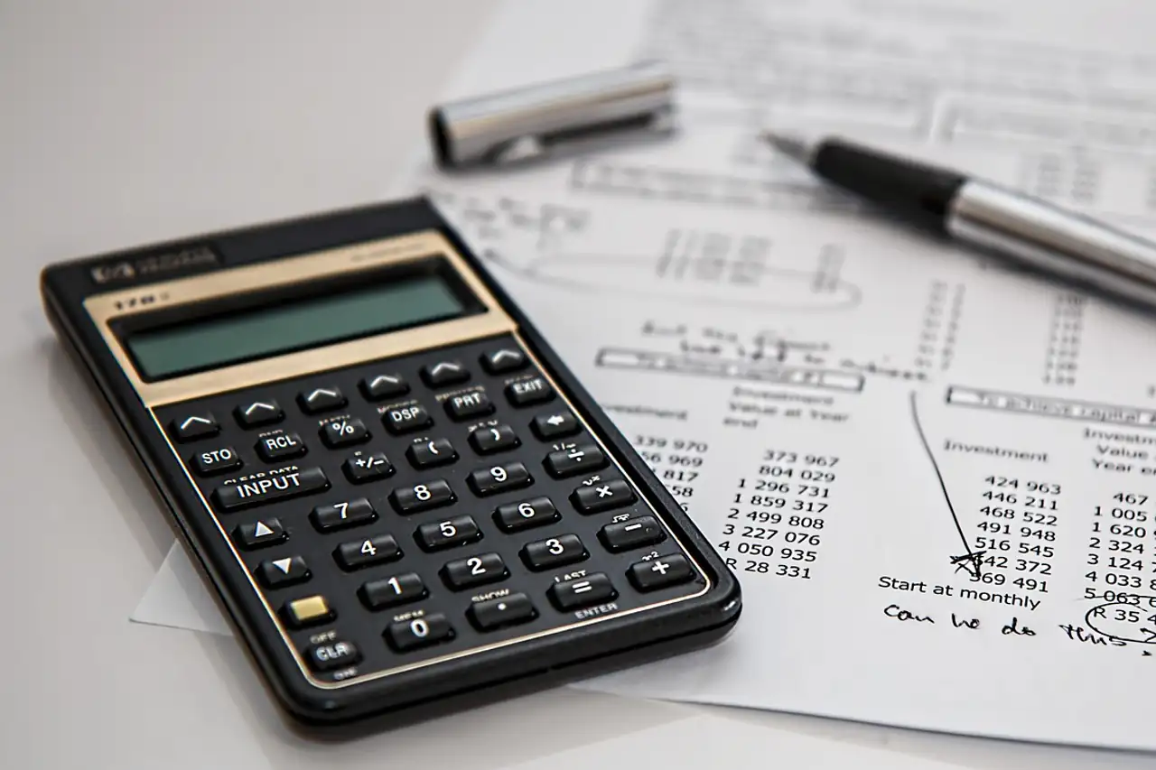 A calculator and pen resting on a printed tax statement