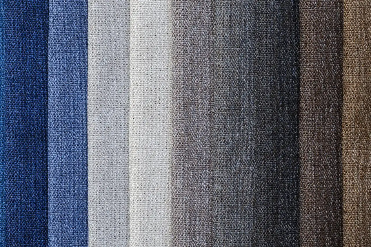 Rolls of fabric in graded shades of blue and grey