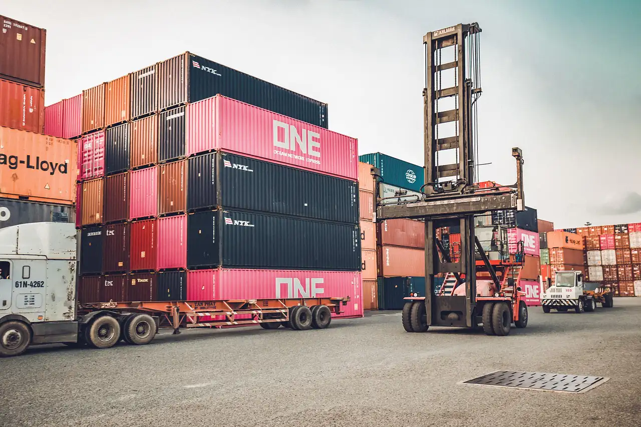 A truck carrying a container through a container yard